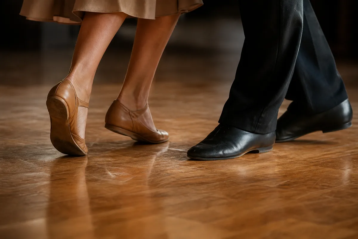 Silhouettes de danseurs de dos dans un studio au parquet clair, bras levés, lumière rasante de fin de journée