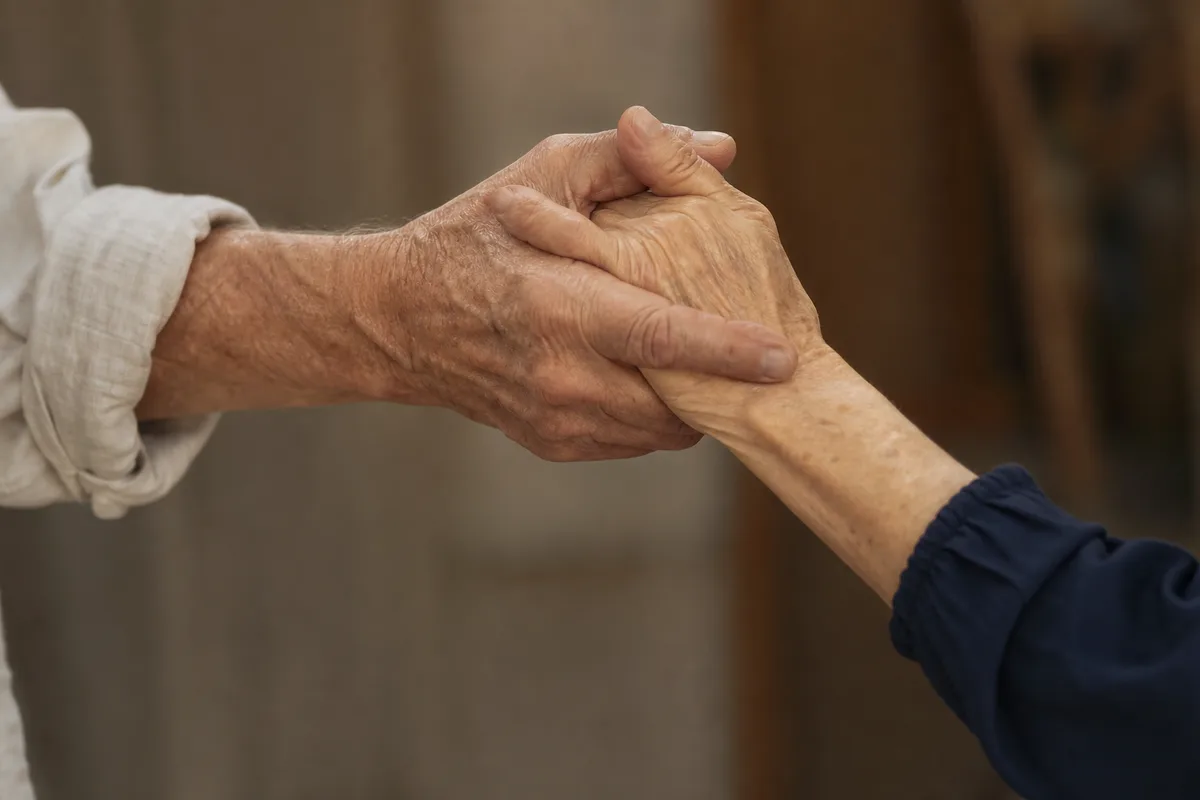 Mains de deux danseurs qui se rejoignent en position de couple, cadrage serré sur les avant-bras, lumière chaude